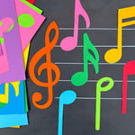 Music notes symbols in multicolor—paper shapes of musical notes and treble clefs, ideal for decorating music sheets and teaching music notation.